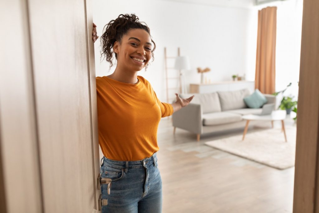 woman smiling opening the door